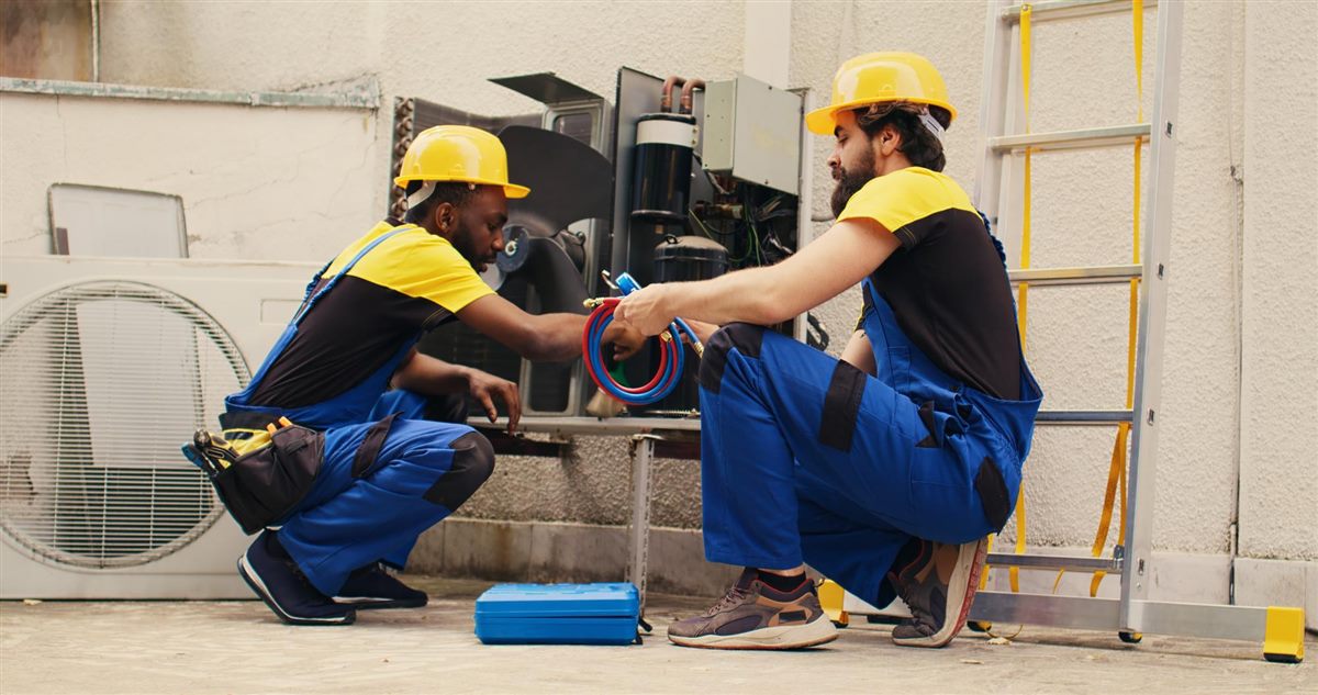 Two Plumbera plumbers servicing pipes together